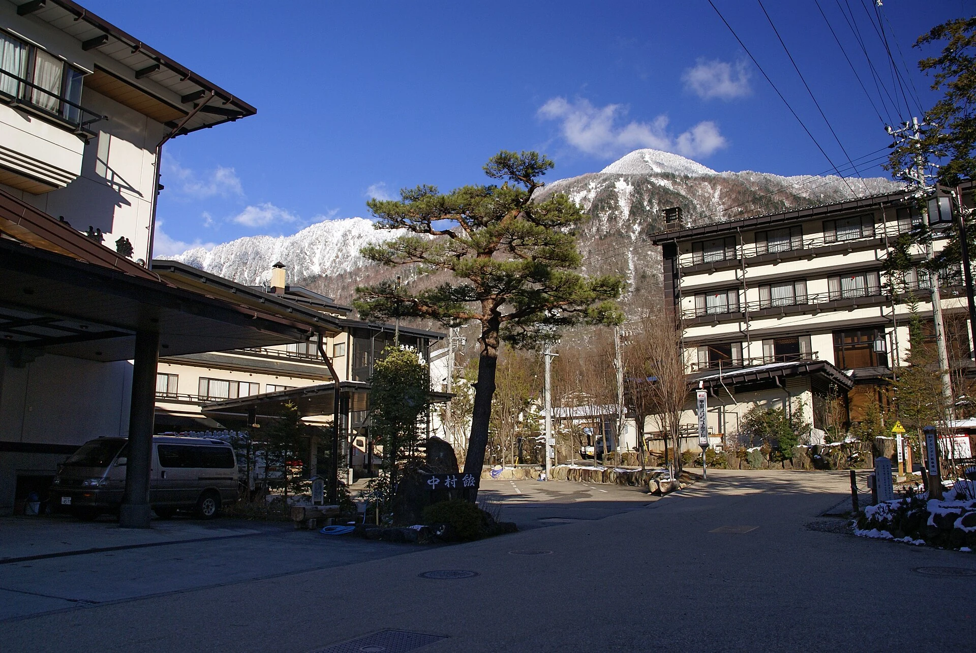 Stone outdoor thermal bath surrounded by deep snow banks