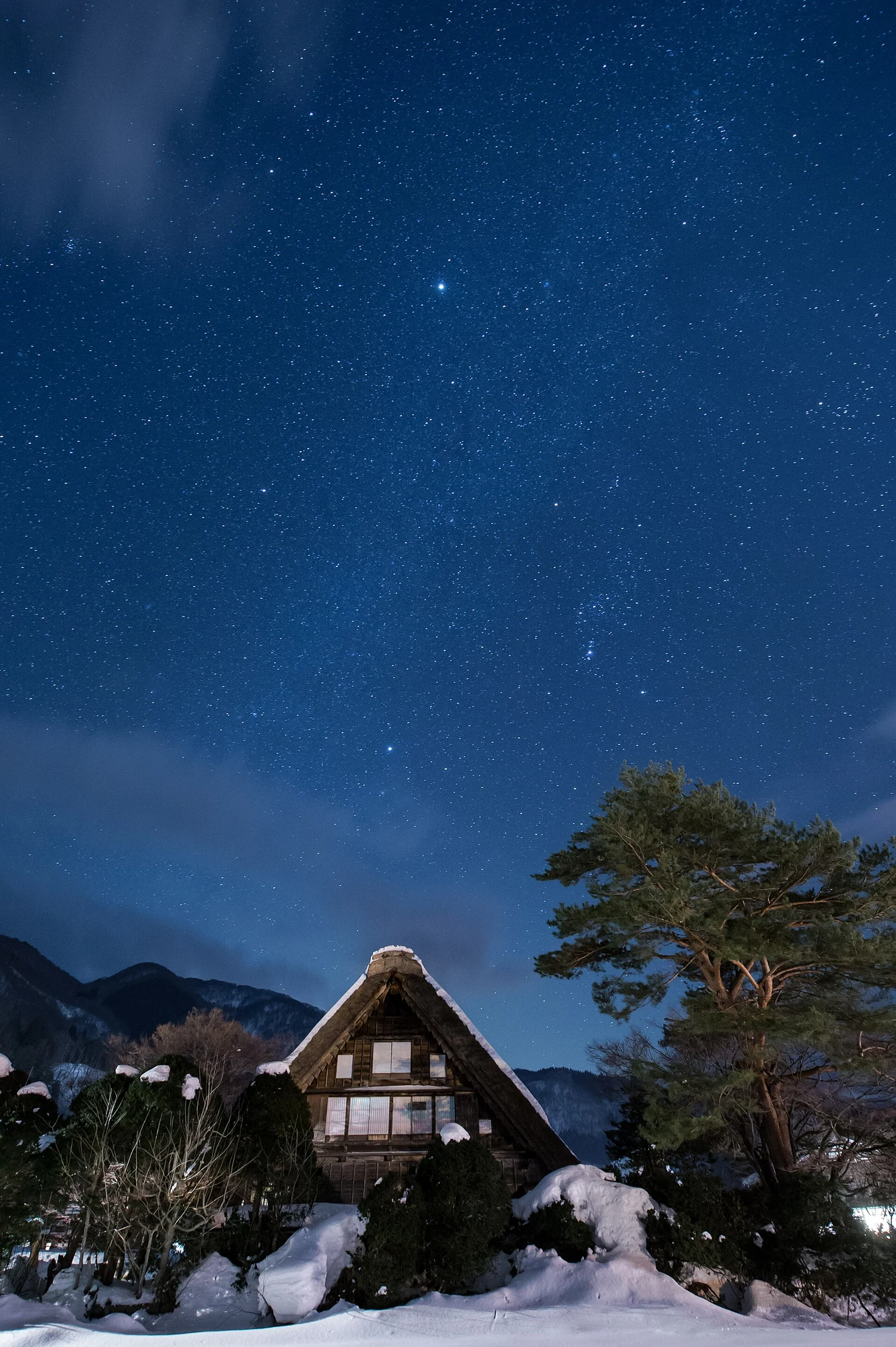 Stars glittering above snow-covered thatched farmhouses in Shirakawa-go